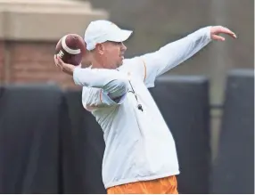  ??  ?? Tennessee head coach Jeremy Pruitt throws the ball during a University of Tennessee football practice Thursday. CAITIE MCMEKIN/NEWS SENTINEL