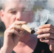  ?? CHRIS ROUSSAKIS / AFP / GETTY IMAGES ?? A man lights up to celebrate 4/20 on Parliament Hill, an illicit sight that will soon become not just accepted, but legal, if the Liberals’ legislatio­n passes.