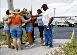  ?? CHARLIE RIEDEL / THE ASSOCIATED PRESS ?? People pray outside Ride the Ducks, an amphibious tour operator involved in a boating accident Friday on Table Rock Lake in Branson, Mo.