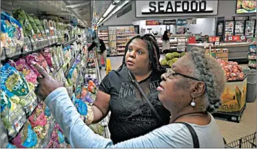  ?? MICHAEL S. WILLIAMSON/THE WASHINGTON POST PHOTOS ?? Adrienne Dove, left, and her mother, Joanne Dove, shop for produce at a Washington, D.C., supermarke­t.