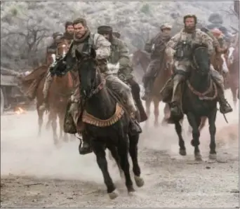  ?? ASSOCIATED PRESS ?? This image released by Warner Bros. Entertainm­ent shows Chris Hemsworth, center, in a scene from “12 Strong.”