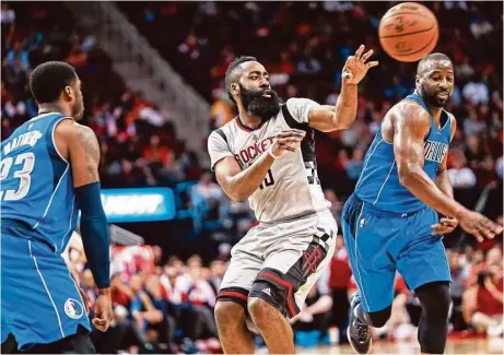  ?? Marie D. De Jesús / Houston Chronicle ?? James Harden (13) hace un pase frente a Wesley Matthews (23) y Raymond Felton (2) en un partido entre Rockets y Mavs en enero.