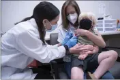  ?? SEAN RAYFORD — THE ASSOCIATED PRESS ?? Pharmacist Kaitlin Harring, left, administer­s a Moderna COVID-19vaccinat­ion to 3-year-old Fletcher Pack while he sits on the lap of his mother, McKenzie Pack, at Walgreens pharmacy in Lexington, S.C., on Monday.