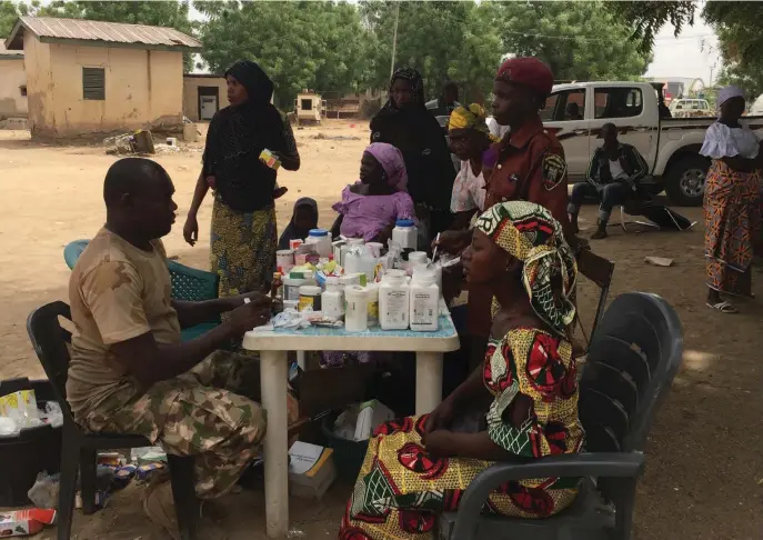  ??  ?? A soldier dispenses drugs to Boko Haram victims in Michika, Adamawa State