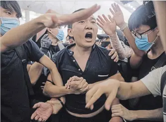  ?? VINCENT YU THE ASSOCIATED PRESS ?? Protesters detain a man they claim was a Chinese undercover agent at a demonstrat­ion at the Hong Kong airport. Demonstrat­ions there have shut down all flights in or out for two days.