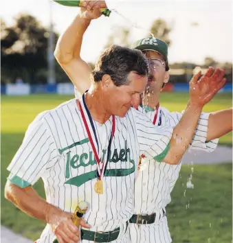  ??  ?? Tecumseh Green Giants manager Don Fields is showered with champagne by Phil Daniel after the team won its first national championsh­ip in August 1992.