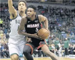  ?? MORRY GASH/AP ?? The Heat’s Derrick Jones Jr. drives past the Bucks’ Malcolm Brogdon during the first Wednesday’s game. half