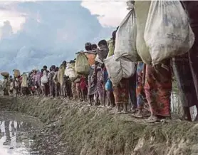  ?? AFP PIC ?? Rohingya refugees crossing the Naf river into Bangladesh. We see injustice born from a troubled past like in the troubled racial history of the United States, Russia’s Stalinism and the genocide of Rohingya in Myanmar.