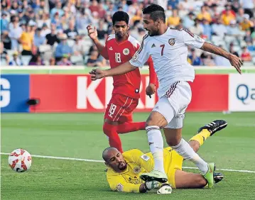  ?? AFP ?? UAE’s Ali Ahmed Mabkhout, right, scores past Bahrain goalkeeper Syed Mohammaed Abbas after just 14 seconds.