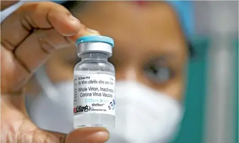  ?? — AFP photo ?? A health staff shows a vial of India’s first indigenous Covid-19 vaccine, ‘Covaxin’ at the Kolkata Medical College and Hospital in Kolkata.