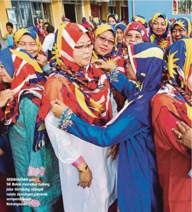  ??  ?? SEBAHAGIAN guru SK Balok memakai tudung Jalur Gemilang sebagai tanda semangat patriotik sempena Bulan Kebangsaan.