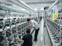  ?? LI ZIHENG / XINHUA ?? Employees operate an intelligen­t production line at a textile plant in Qingdao, Shandong province.