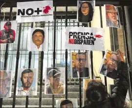  ?? Eduardo Verdugo Associated Press ?? PHOTOS OF SLAIN journalist­s are posted during a Mexico City protest in January. Mexico is the deadliest country for journalist­s this year outside of war zones.