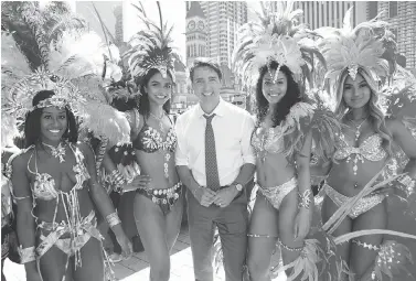  ?? CHRIS YOUNG / THE CANADIAN PRESS ?? Prime Minister Justin Trudeau stops for a photo with dancers from the Toronto Caribbean Carnival on Friday.