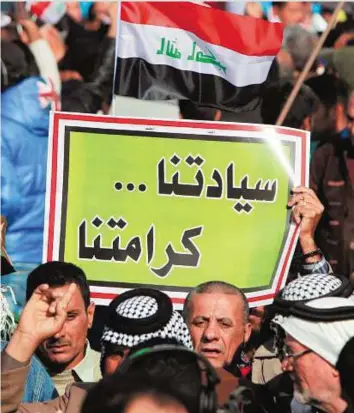 ?? AFP ?? Iraqi protesters, most of them members of Shiite paramilita­ry forces, hold a placard reading in Arabic “Our sovereignt­y is our dignity” as they gather in Baghdad’s Tahrir Square yesterday to demand the withdrawal of Turkish forces from Iraq. Iraq says...