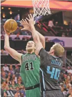  ?? CHUCK BURTON/THE ASSOCIATED PRESS ?? The Celtics’ Kelly Olynyk shoots over the Hornets’ Cody Zeller on Saturday in Charlotte, N.C. Boston won and remains in contention for the No. 1 seed in the Eastern Conference playoffs.