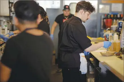  ?? GABRIELLA DEMCZUK / THE NEW YORK TIMES ?? Workers prepare food orders earlier this year at Taco Bamba Taqueria in Falls Church, Va., where business is robust but staff is in short supply. The National Restaurant Associatio­n reports that 37 percent of its members said labor recruitmen­t was...