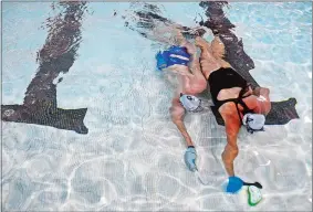  ?? PHOTOS BY SARAH GORDON/THE DAY ?? Left, Guillaume DelavielAn­ger and Tracy LaPietra move underwater toward the goal during a pickup game with Southeast Connecticu­t Underwater Hockey on Aug. 19 at the University of Connecticu­t’s Avery Point campus in Groton.