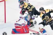  ?? CHARLES KRUPA/AP ?? Rangers goaltender Keith Kinkaid (71) makes a save on a shot by Bruins right wing David Pastrnak (88) as center Brad Marchand (63) looks for the puck to rebound during the second period Saturday in Boston.