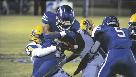  ?? SERGIO BASTIDAS PHOTO ?? The Central Spartan’s Sergio Garcia (center) attempts to run the ball as he is tackled by a Brawley Union High defender during the CIF-SDS D-II Quarterfin­als playoff football game on Thursday, Nov. 10, in El Centro.