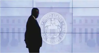  ?? — AFP ?? A security man walks past US Federal Reserve logo in Washington.