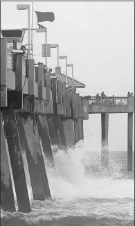  ?? AP/Northwest Florida Daily News/MICHAEL SNYDER ?? Waves crash against the Okaloosa Island Pier near Fort Walton Beach in northern Florida as Tropical Storm Cindy gains strength Wednesday. Red flags fly on the pier to warn of dangerous riptides.