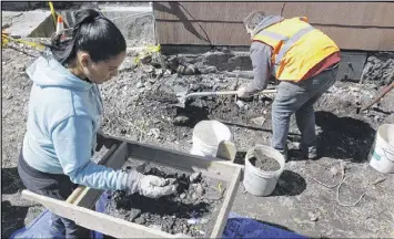  ?? BILL SIKES / AP ?? Archaeolog­ist Joseph Bagley (right) digs as volunteer Rosemary Pinales sifts soil for items at the house where slain African-American activist Malcolm X lived for a time with his sister’s family in the 1940s in the Roxbury section of Boston.