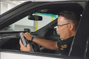  ?? NEWS PHOTO MO CRANKER ?? Above: Medicine Hat Police Service S-Sgt. Jason Graham checks Twitter before getting out of his vehicle around 1:00 a.m. Sunday, just a few hours before his overnight shift, and virtual ride-along event came to a close.