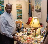  ?? (Arkansas Democrat-Gazette/Cary Jenkins) ?? Henri Linton with printed studies of a large painting in his Pine
Bluff studio