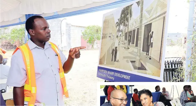  ??  ?? A constructi­on worker checks out one of the drawings of what the new Hampden Wharf Developmen­t will look like.