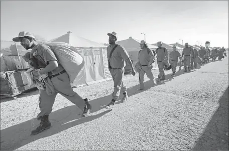  ?? Photograph­s by Al Seib Los Angeles Times ?? INMATES take a break between shifts as they work with the California Department of Correction­s and Rehabilita­tion battling the Thomas fire in Ventura. Establishe­d in 1943, the inmate fire program employs roughly 3,800 prisoners across California.