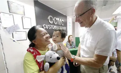  ??  ?? SISTER CITY – Peter Janssen, a member of the delegation from Haarlemmer­meer town, Netherland­s, talks to a mother and her child during yesterday’s ceremonies where his group turned over a donation of 10,000 euros (about to help the pediatric ward of the...