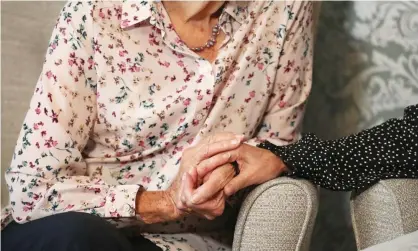  ?? Photograph: Andrew Matthews/PA ?? A care home resident holding hands with her daughter. The government is being warned of widespread closures of care homes unless it scraps the “no jab, no job” law in England.