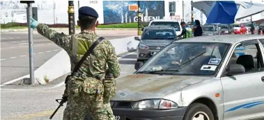  ?? — Bernama ?? For their own good: a soldier ordering a motorist to turn back at a roadblock at the Sultan iskandar Highway in Johor Baru.