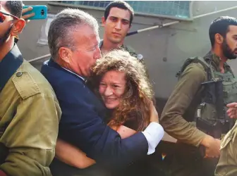  ?? AP ?? ■ Ahed Tamimi is hugged by her father Bassem after she was released from an Israeli prison yesterday, at the entrance of her village of Nebi Saleh in the West Bank.