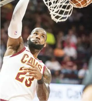  ??  ?? Cleveland Cavaliers' LeBron James dunks against the Chicago Bulls during the first half of an NBA preseason basketball game in Cleveland Tuesday. (AP)