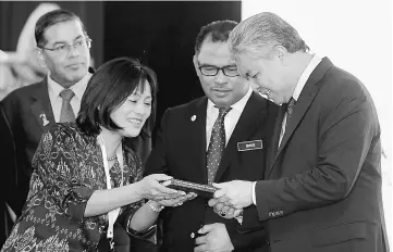  ?? — Bernama photo ?? Ahmad Zahid (right) receives a souvenir from UN Habitat Bangkok chief Mariko Sato after launching the 17th Internatio­nal Melaka Twin Cities Convention 2017. Looking on at second right is Idris.