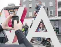  ?? DARREN BROWN ?? Barbara Curran, left, takes a picture of, from top right, Vuk Stojnic, Casia Stojnic and Javor Stojnic, as they pose on the OTTAWA sign inside Inspiratio­n Village in the Byward Market on Monday,