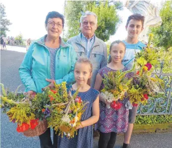  ?? FOTO: JOSEF SCHNEIDER ?? Für viele ist Mariä Himmelfahr­t ein Feiertag, an dem sie ihre Kräuter- und Blumenbüsc­hel im Gottesdien­st segnen lassen. Irmgard und Josef Gärtner aus Jagstzell (von links) besuchten mit ihren Enkelkinde­rn Julia, Leonie und Florian die Schönenber­gkirche.