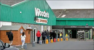  ??  ?? chore values: The queue at Woodie’s in Sallynoggi­n yesterday, with gas cylinders separating the DIY shoppers