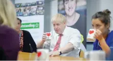  ?? — AFP ?? Britain’s Prime Minister Boris Johnson speaks to mental health profession­als during his visit to Watford General hospital in Watford on Monday.