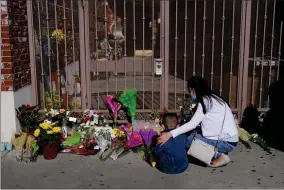  ?? AP PHOTO BY JAE C. HONG ?? A woman comforts her son while visiting a makeshift memorial outside Star Dance Studio in Monterey Park, Calif., Monday, Jan. 23, 2023. Authoritie­s searched for a motive for the gunman who killed 10 people at the ballroom dance club during Lunar New Year celebratio­ns.