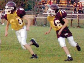  ?? MARK HUMPHREY ENTERPRISE-LEADER ?? Soggie Holcomb (right wearing jersey 76) and teammate Dylan King pursue a play from the back side during the Meet the Wolves scrimmage featuring the Lincoln seventh grade offense against the eighth grade defense on Aug. 23. Holcomb is in his second...