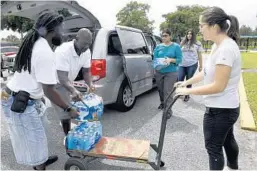  ?? TAIMY ALVAREZ/SOUTH FLORIDA SUN SENTINEL ?? Volunteers Elijah Cotton, from left, Alex Weaver and Hallandale Beach Vice Mayor Sabrina Javellana collect donations at Koinonia Worship Center & Village on Tuesday.