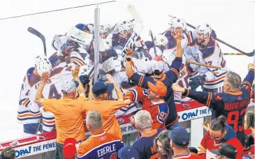  ?? USA TODAY SPORTS ?? Oilers players and staff celebrate after Connor McDavid scores against the Flames in overtime.