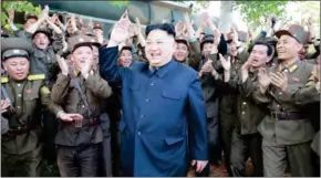  ?? MANDEL NGAN/AFP ?? North Korean leader Kim Jong-un (centre) smiles while inspecting the test-firing of the medium-to-long range ballistic missile Pukguksong-2 last week.