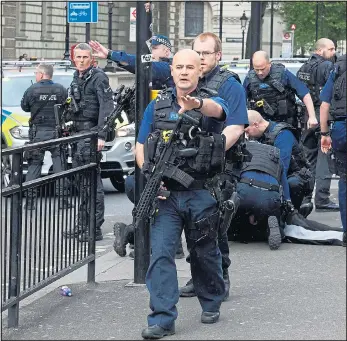  ?? Pictures: NIKLAS HALLE’N/AFP, STEPHEN LOCK/i-IMAGES, TOBY MELVILLE/REUTERS ?? Police surround the suspect as he lies face down on a traffic island in Parliament Street