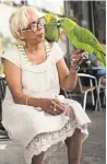  ??  ?? Asha McLeod enjoys an afternoon snack with her five Amazon parrots outside of her local Second Cup.