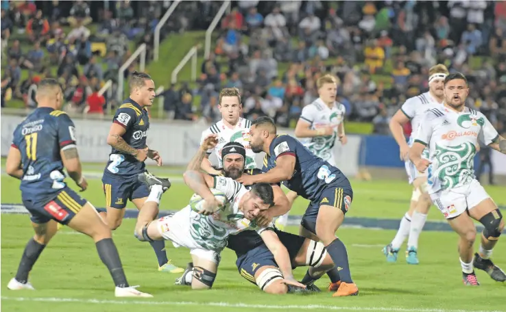  ?? Photo: Ronald Kumar ?? Chiefs flanker Luke Jacobson (with ball) is stopped on attack by Highlander­s’ defenders during their Super Rugby match last night at Suva’s ANZ Stadium.