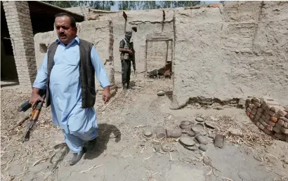  ?? Reuters ?? A policeman in plain clothes walks out of a damaged house, which witnesses said belonged to Hafeez Brohi, wanted in connection with bombings in Shikarpur and suspected in many other blasts in Sindh province, on the outskirts of Shikarpur. —